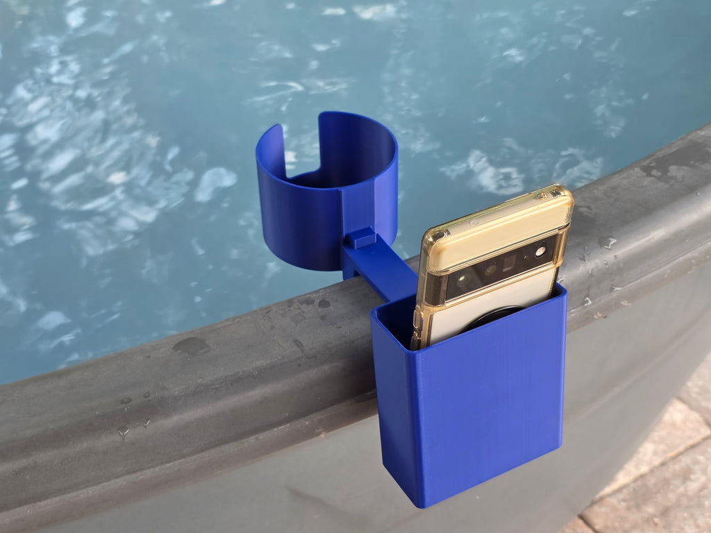 A blue 3D-printed cup and phone holder attached to the edge of a stock tank. The phone holder is holding a smartphone with a clear case. The cup holder is designed to hold a beverage.
