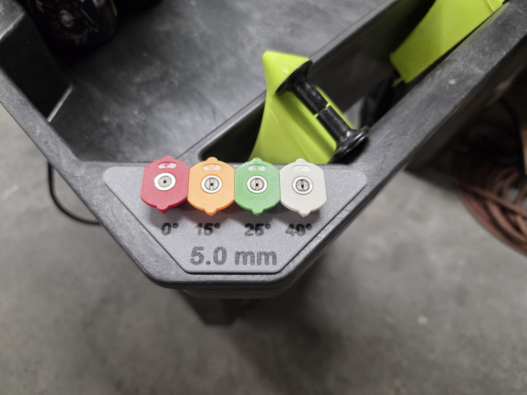 A close-up of a pressure washer nozzle holder with four colored nozzles: red (0°), orange (15°), green (25°), and white (40°). The holder is gray with black text showing "5.0 mm" for the orifice size and a black label for each nozzle's location. 