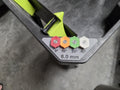 A close-up of a pressure washer nozzle holder with four colored nozzles: red (0°), orange (15°), green (25°), and white (40°). The holder is gray with black text showing "6.0 mm" for the orifice size and a black label for each nozzle's location. 