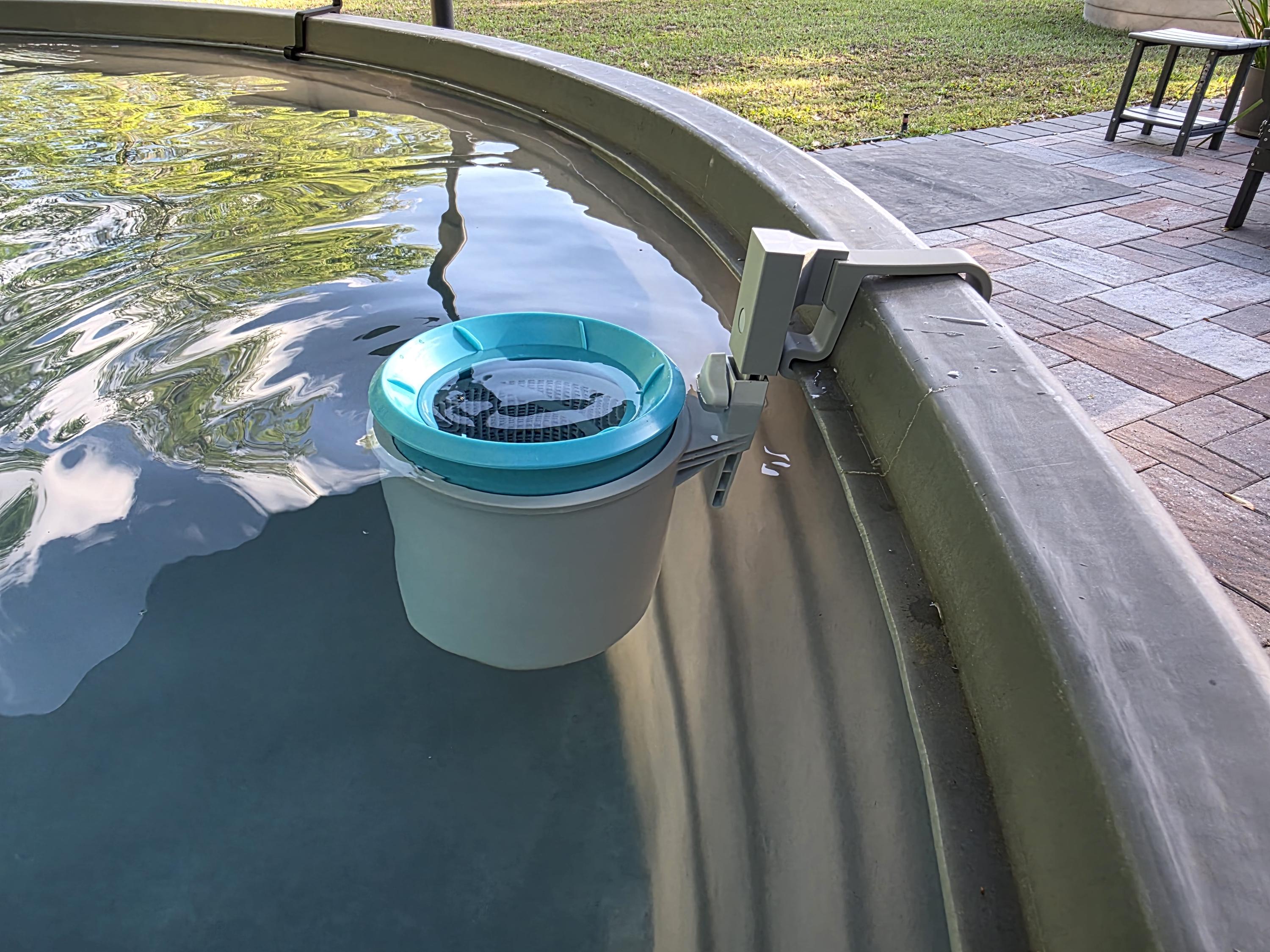 An Intex above ground pool skimmer installed onto a grey poly stock tank using a grey 3D printed bracket and a grey adapter to the Intex skimmer support rod. 